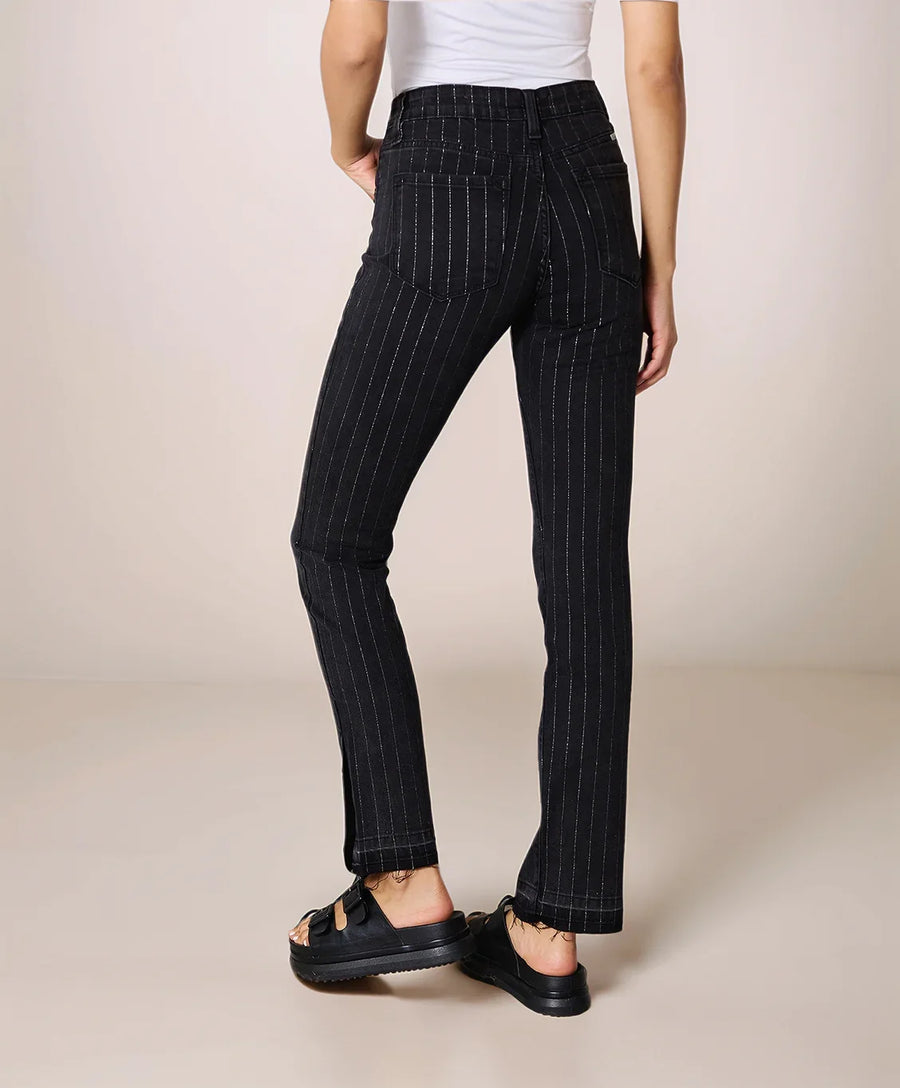 Person wearing black pinstripe pants on a beige background