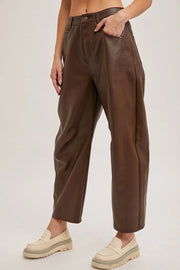 Brown leather pants worn by a person on a plain background
