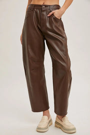 Brown leather pants worn by a person on a plain background