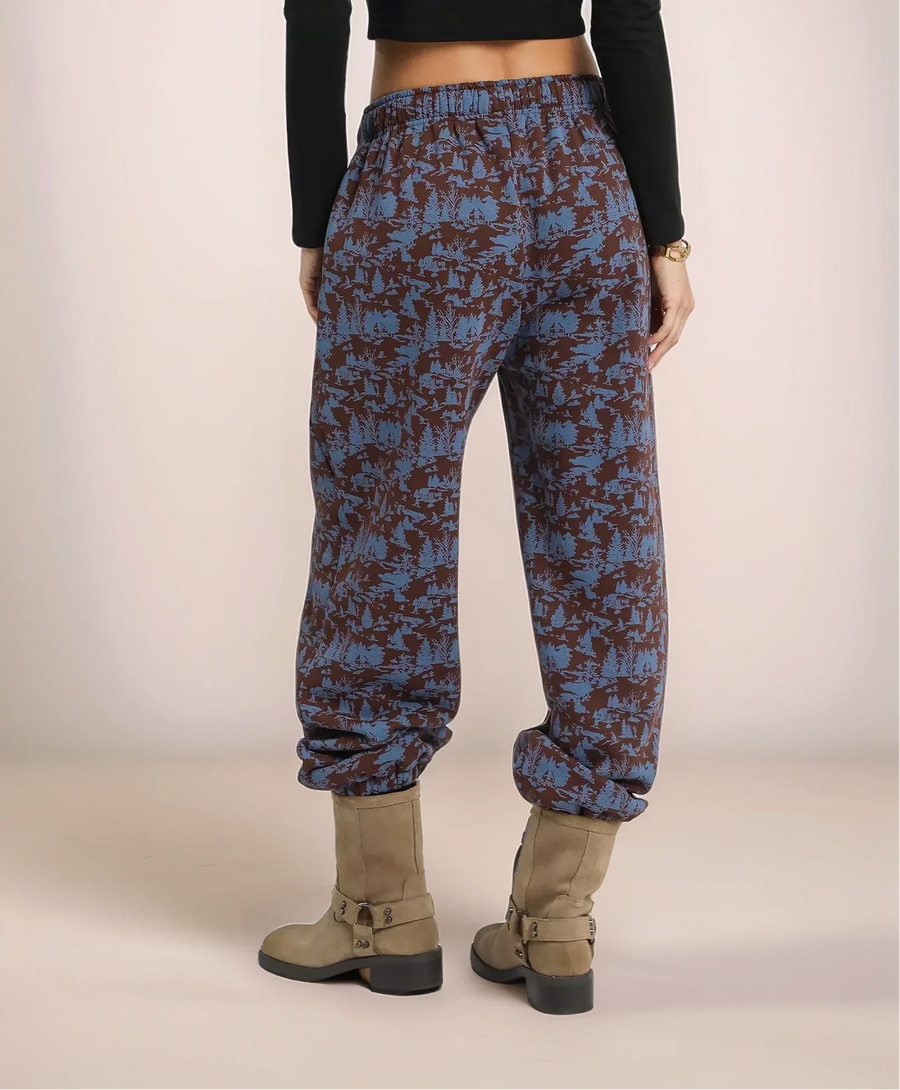 Person wearing blue and brown patterned pants on a plain background