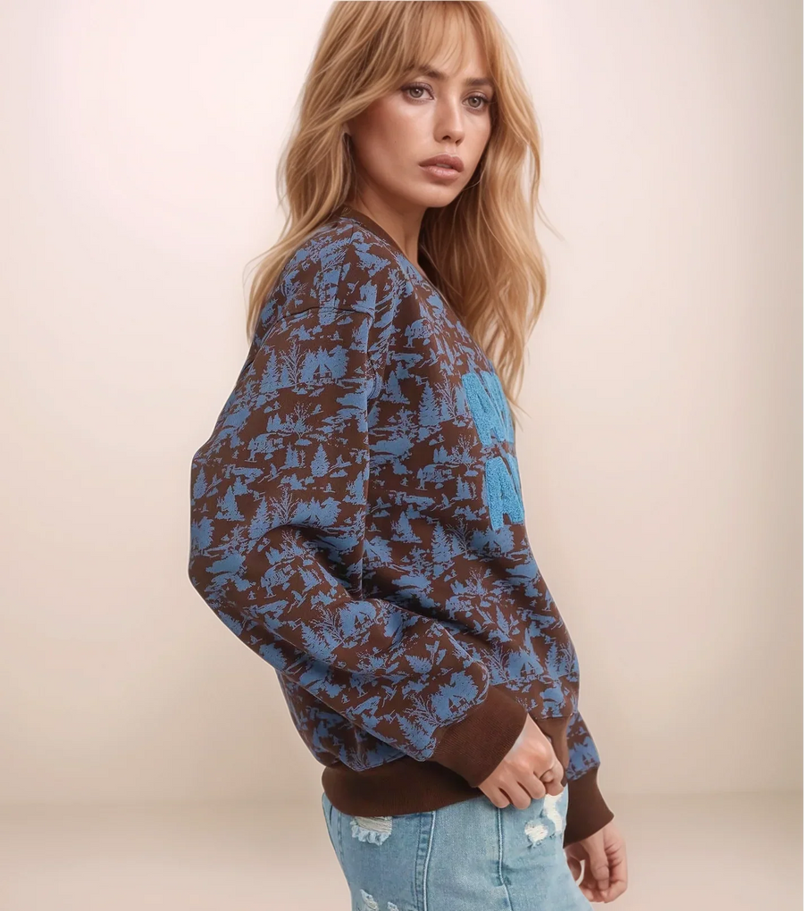 Woman wearing a blue and brown patterned sweater against a beige background
