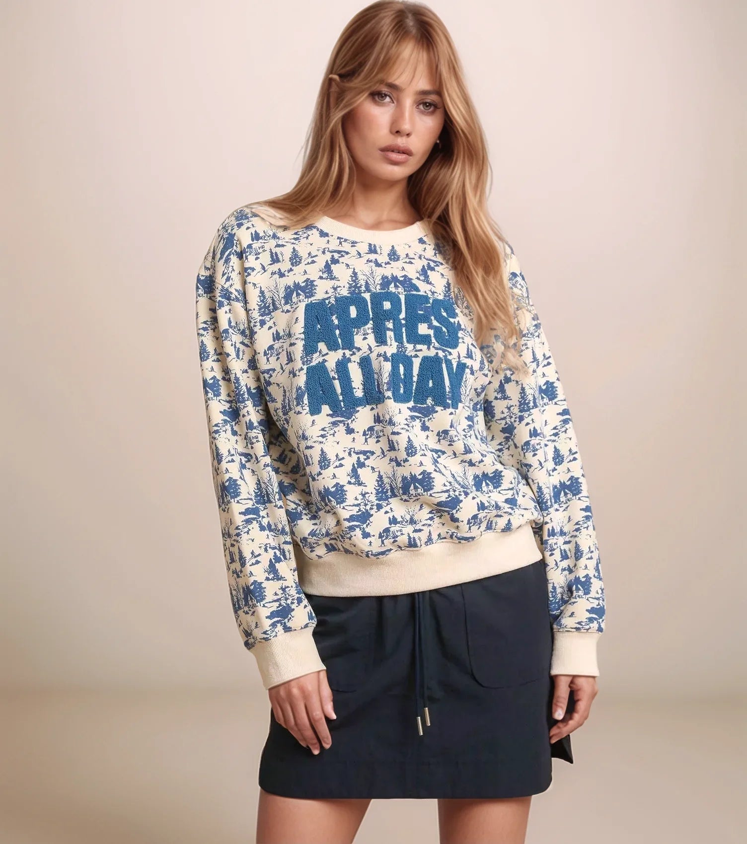 Woman wearing a patterned sweater with 'APRES ALL DAY' text on a beige background