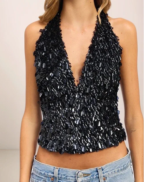 Black beaded halter top worn by a model on a plain background