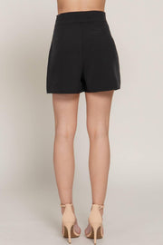 a pair of black tailored shorts on a woman facing backwards