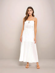 Woman wearing a white dress against a plain background