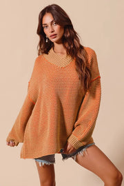 Woman wearing an orange knit sweater over a denim skirt on a beige background