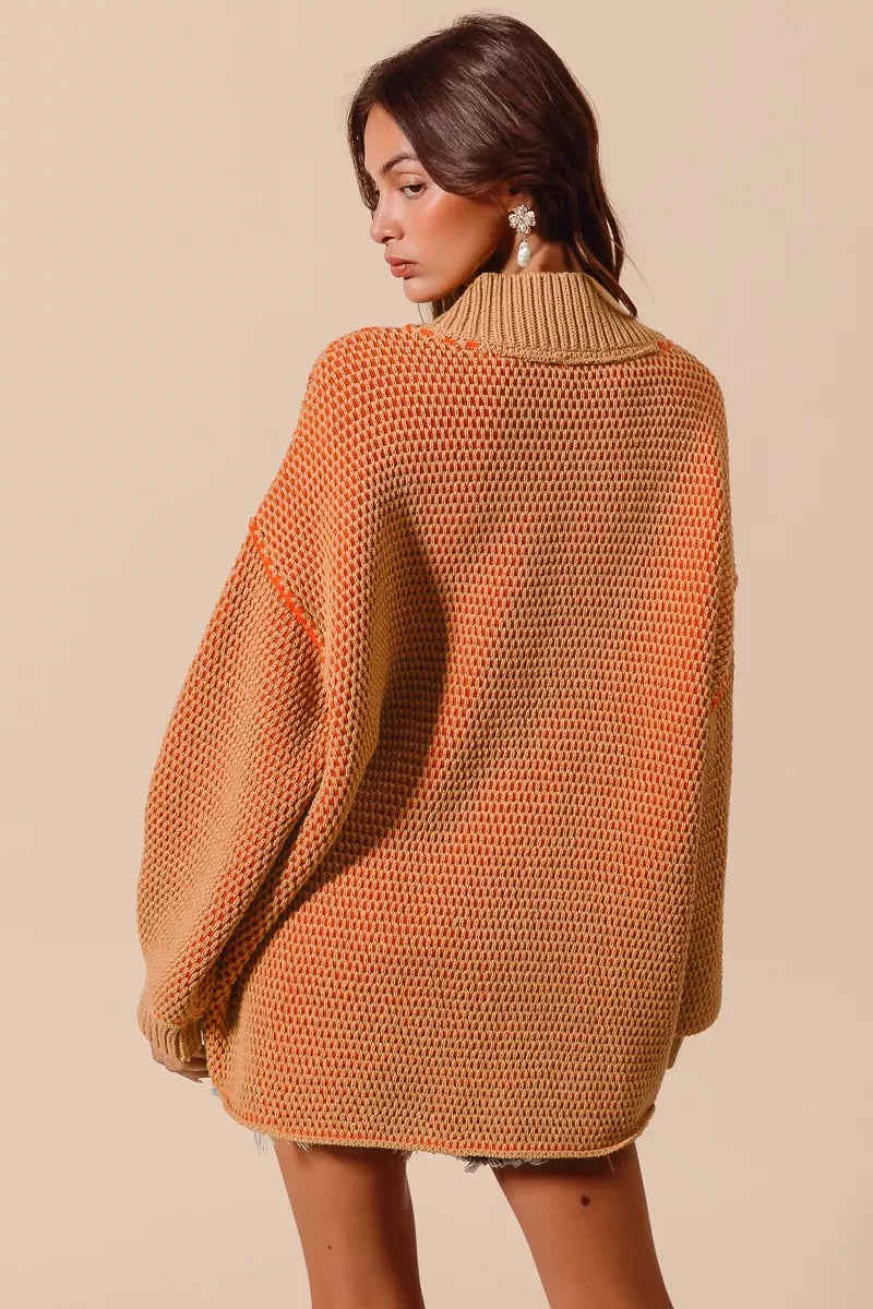 Woman wearing an orange and tan knitted sweater against a beige background