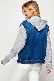 Person wearing a dark blue denim vest over a gray hoodie on a white background