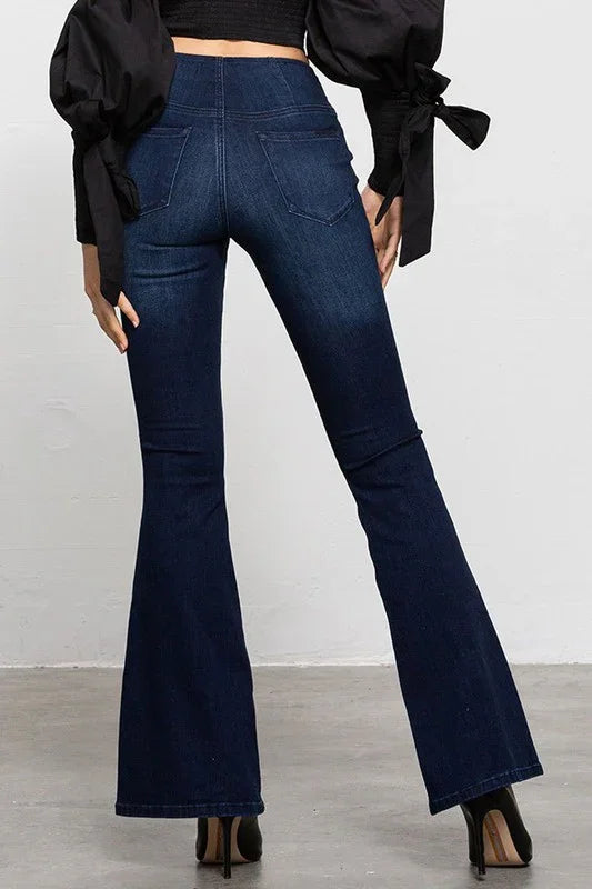 Navy blue flared jeans worn by a person on a plain background