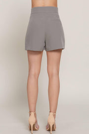 a pair of gray tailored shorts on a woman facing backwards from the waist down