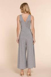 a blonde woman modeling the back of a gray sleeveless knit surplice jumpsuit