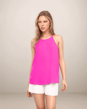 a blonde woman is wearing white shorts with a hot pink halter tank top with scalloped trim at the armholes