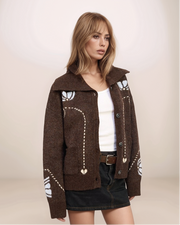 Woman wearing a brown patterned jacket on a plain background