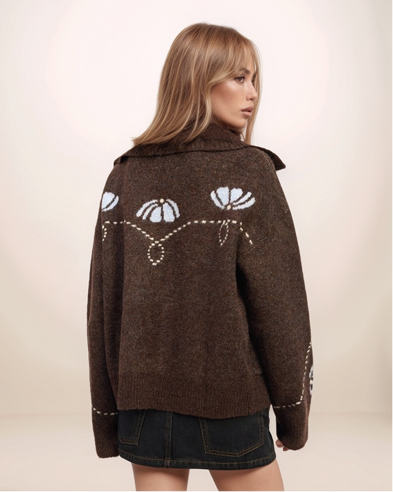 Woman wearing a brown jacket with cat face design on a beige background