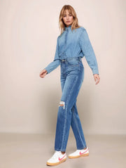 Woman wearing a denim outfit with a plain background