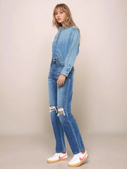 Woman wearing a denim outfit with a beige background