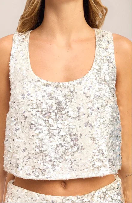 a woman wearing a ivory sequin tank top and matching bottom