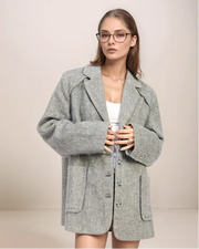 Woman wearing a gray coat against a plain background