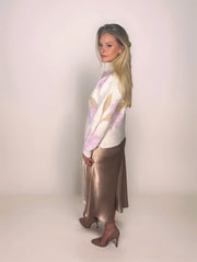 a stylish woman is wearing a floral sweater with a satin skirt