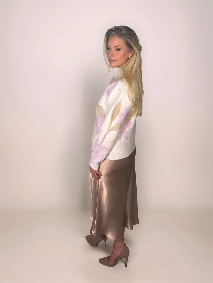 a stylish woman is wearing a floral sweater with a satin skirt