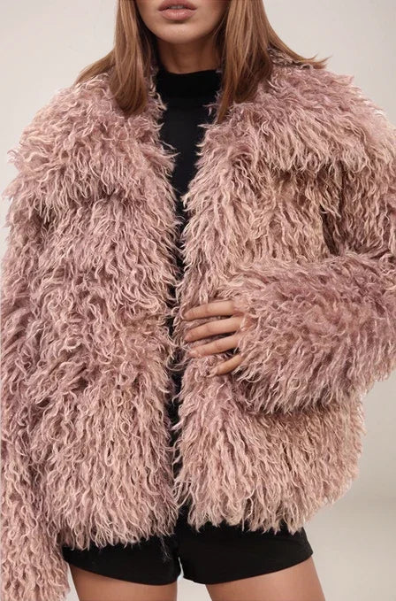 Person wearing a fluffy pink jacket against a neutral background