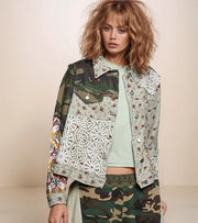 woman wearing a floral and camo patchwork jacket with camo pants.
