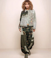 a woman wearing a patchwork jacket with camo pants.