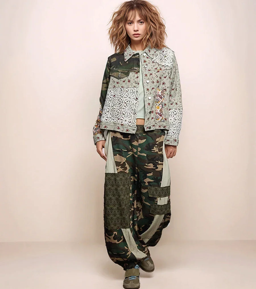 a woman wearing a patchwork jacket with camo pants.