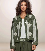 Woman wearing a green jacket with floral patterns on a plain background