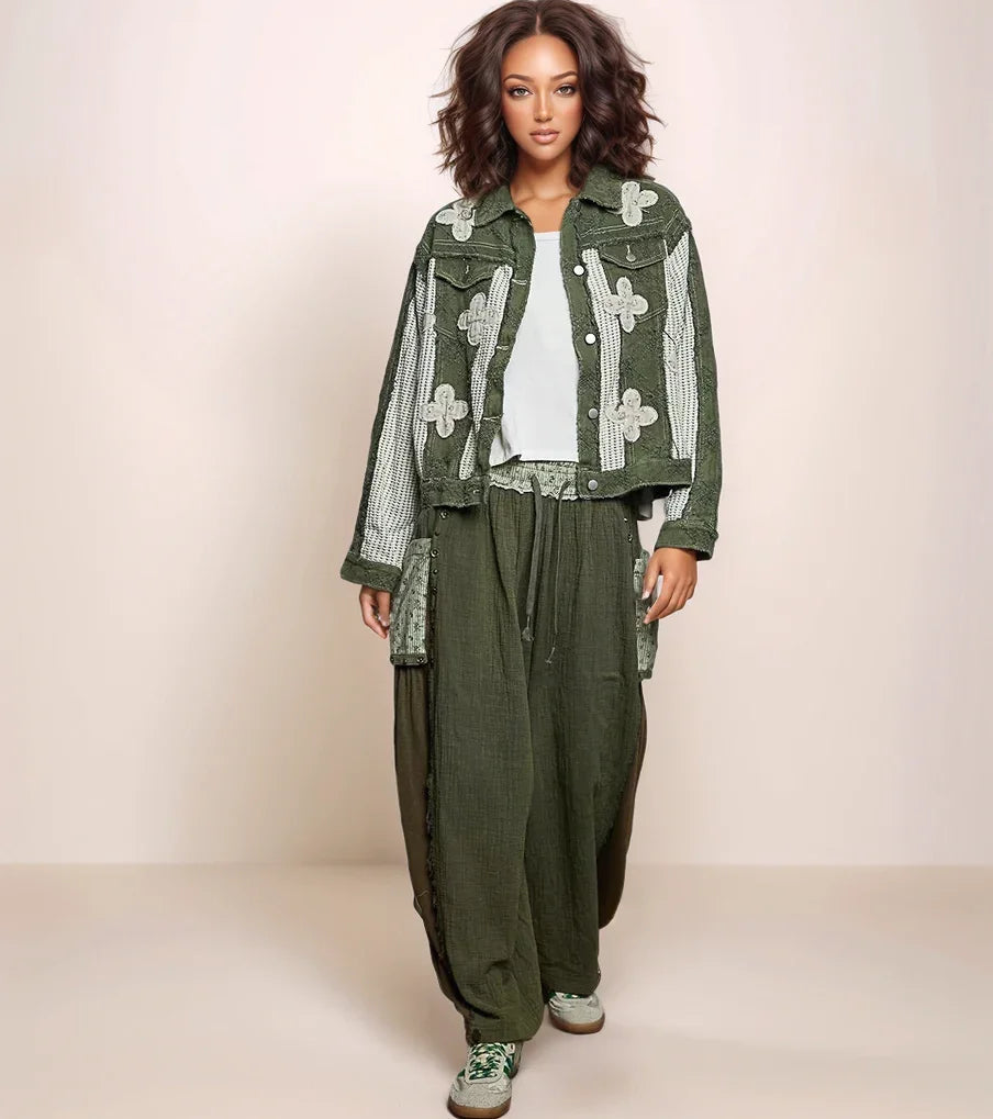 Woman wearing a green floral jacket and pants on a plain background