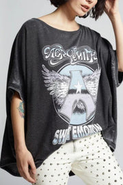 Person wearing a dark gray t-shirt with a graphic design on a plain background