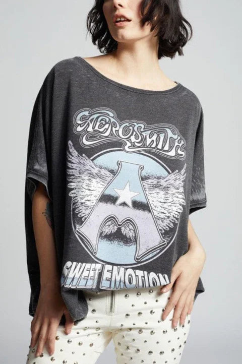Person wearing a dark gray t-shirt with 'Aerosmith Sweet Emotion' design on a plain background