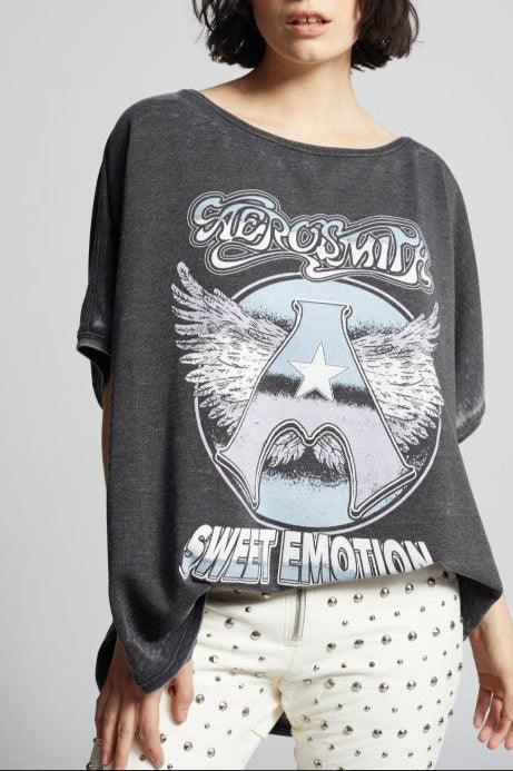 Person wearing a dark gray t-shirt with Aerosmith 'Sweet Emotion' design on a plain background