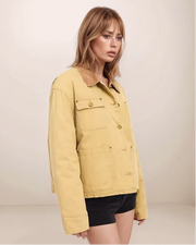 Woman wearing a yellow jacket against a plain background