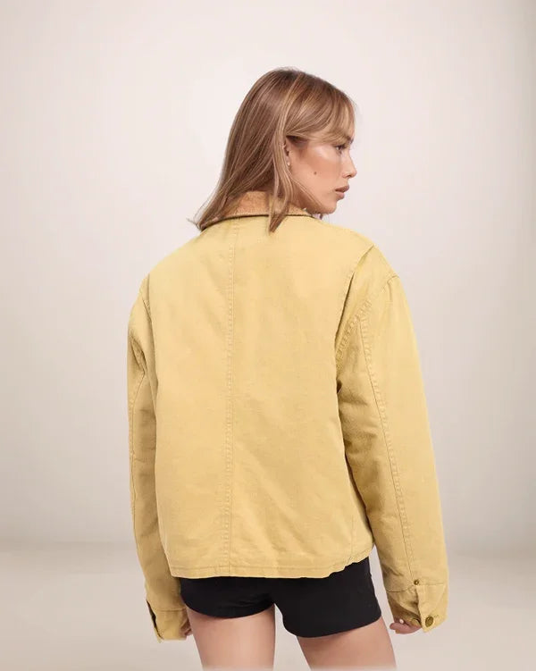 Woman wearing a yellow jacket on a plain background