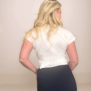 a blonde woman is wearing a white wrap top that is tied in the back.