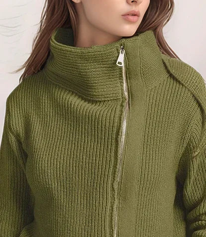 Woman wearing a green zip-up sweater against a plain background