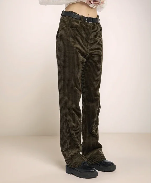 olive green corduroy pants worn by a person on a plain background