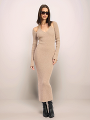 Woman wearing a beige ribbed dress against a plain background