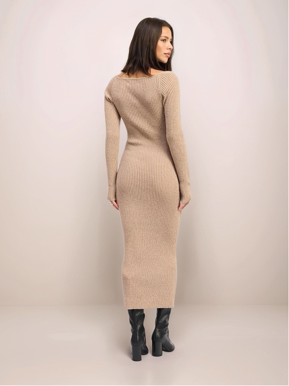 Woman wearing a beige ribbed knit dress against a plain background