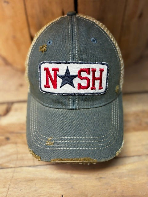 Distressed blue cap with 'NASH' patch on a wooden surface