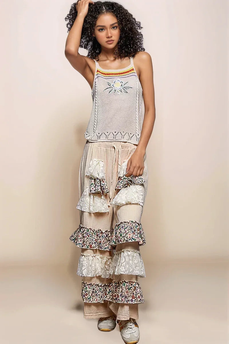Full-body lifestyle shot of a model wearing the POL Solstice Embroidered Tank paired with layered cream ruffle and floral lace pants, embodying a sophisticated bohemian aesthetic.