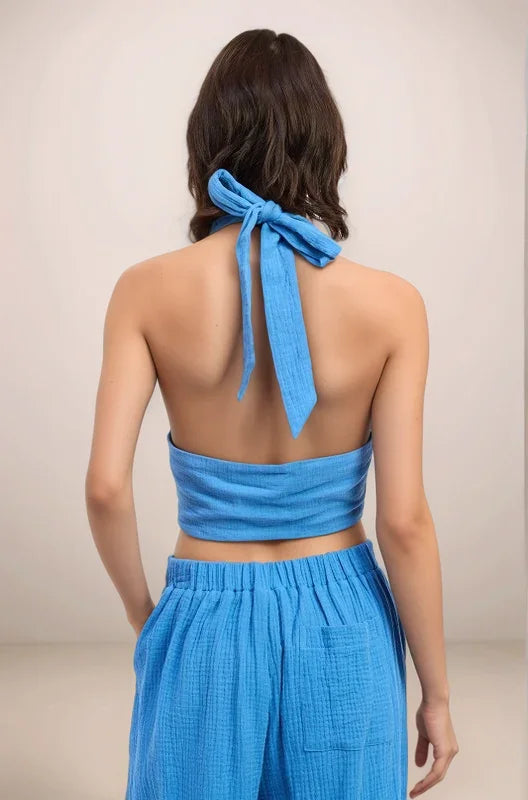 Back view of the Aegean blue halter top, highlighting the skin-baring open back and the adjustable knot tie at the nape of the neck.