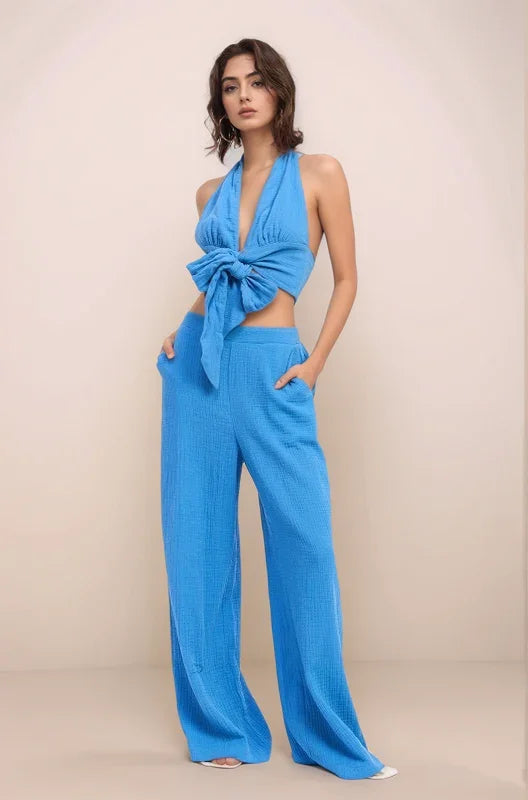 Full-body view of a model wearing the Aegean halter crop top paired with the matching high-waisted wide-leg gauze pants, illustrating a cohesive coastal-chic set.