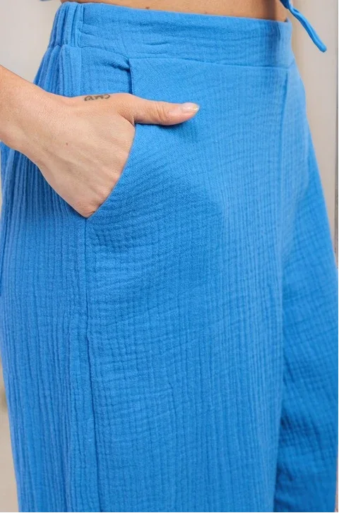 Side view of the Aegean pants on a model, showcasing the high-waisted silhouette and the effortless, airy drape of the fabric and the side pockets
