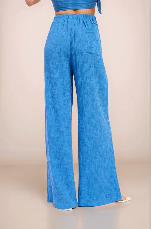 Back view of the Aegean wide-leg pants showcasing the comfortable elastic waistband and functional patch pocket detail.