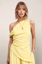Front-facing view of the yellow Marais pinstripe top, highlighting the modern one-shoulder neckline and the dramatic diagonal asymmetrical hemline.