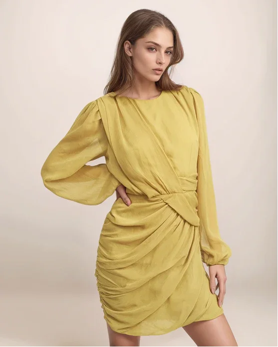 Woman wearing a yellow dress with long sleeves on a beige background