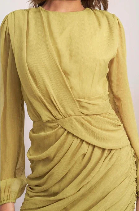 Yellow dress with long sleeves and a draped design on a white background