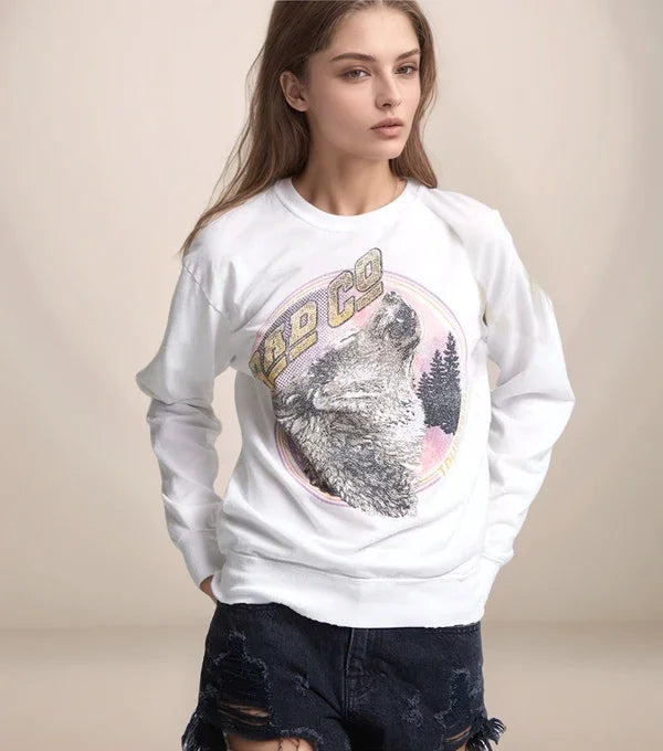 Person wearing a white sweatshirt with a wolf graphic and 'REDCO' text on a beige background